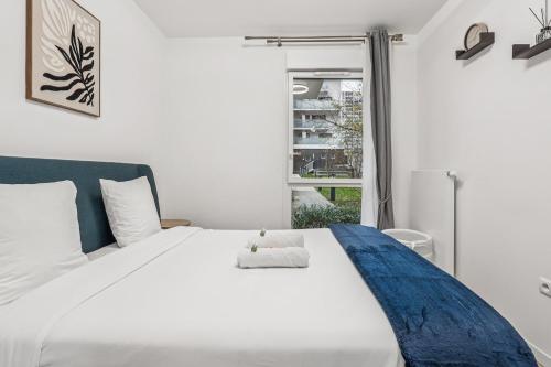 a white bed in a room with a window at NK Apartment in Bobigny in Bobigny