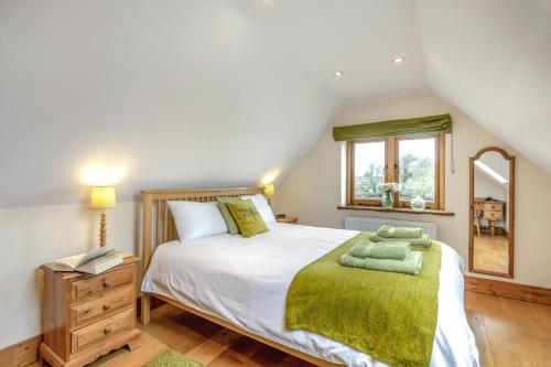 a bedroom with a large bed with a green blanket at 3 Bed in Tenterden oc-p36303 in Tenterden