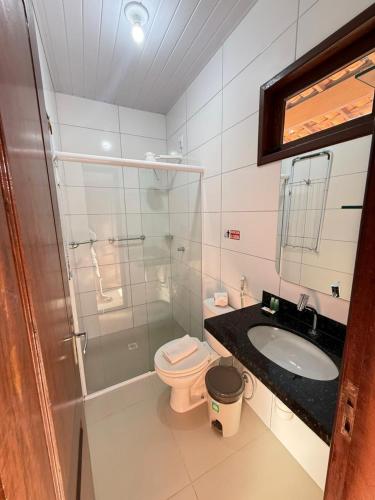 a bathroom with a shower and a toilet and a sink at Portal do Sol Lençóis Pousada in Barreirinhas