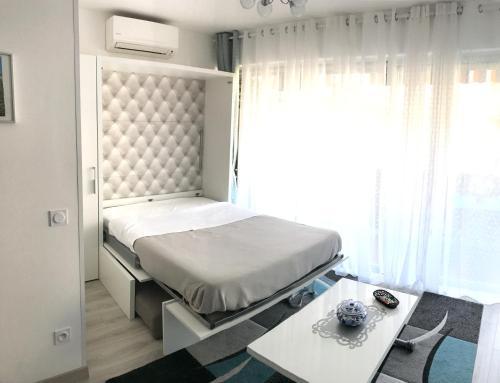 1 dormitorio con cama, mesa y ventana en Le Paradis Blue, en Niza