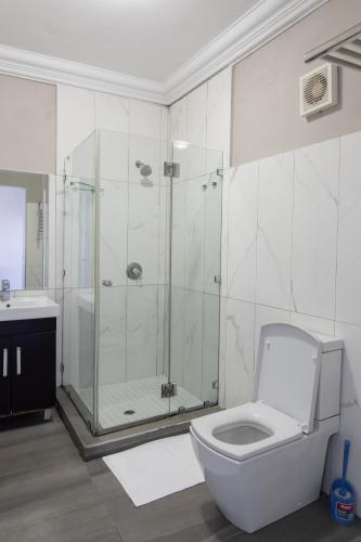 a bathroom with a shower and a toilet and a sink at Marilyn Boutique Hotel in Durban
