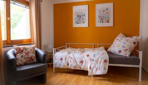 a bedroom with a bed and a chair at Elfriedes' Ferienhäuschen in Marktschorgast