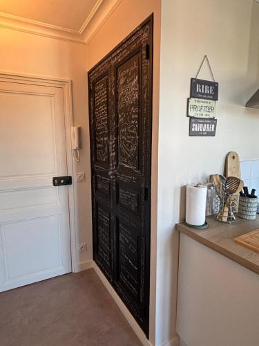 a black door in a room with a counter at "Le Cocon Douessin" en hyper centre ! in Doué-la-Fontaine