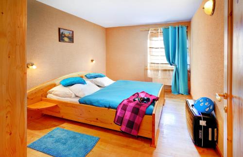 a bedroom with a bed and a suitcase in it at Apartmány Renomal in Vysoke Tatry - Tatranska Lomnica.