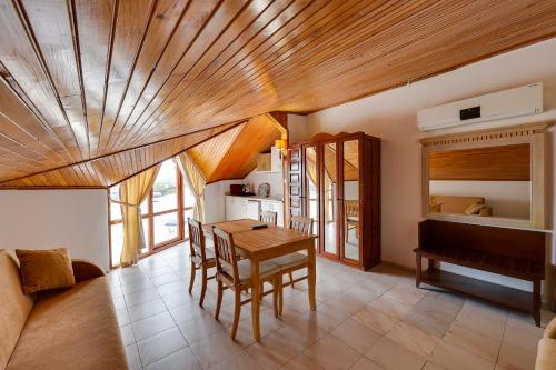 a living room with a wooden ceiling and a table at NATURELLA APART HOTEL in Kemer