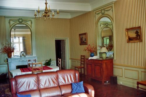 a living room with a couch and a bed and mirrors at Hôtel du Château de Cabrières in Saint-Jean-du-Gard