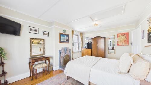 a bedroom with a white bed and a tv at Room with a View at Anchor Down Cottage in Ryde