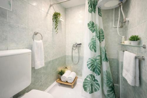 a bathroom with a shower curtain and a toilet at Vila Kosta City Center Port in Ohrid