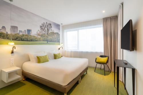 a hotel room with a large bed and a window at BW Plus Central Park Hotel & Spa in La Rochelle