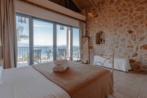 a bedroom with a bed with a view of the ocean at Lilian Horizon in Tolo
