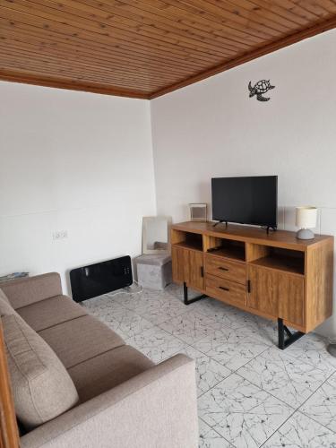 a living room with a couch and a flat screen tv at Mein Faial, Apartment with Pico and Seaview in Horta