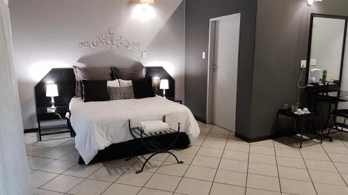 a bedroom with a large bed with white sheets and pillows at Siesta Guest House in Musina