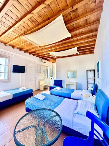 a room with three beds and a table and chairs at Anna in Megali Ammos