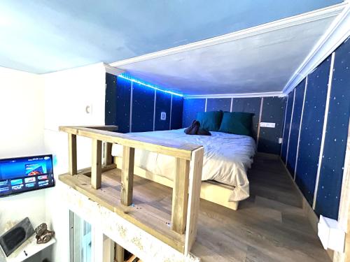 a bed in a room with a blue wall at Charmant cocon, Lagny sur marne, parking, wifi, proche Disney RER in Lagny