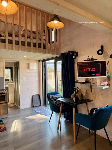 a living room with a loft bed and a table and chairs at Le Cabanon - Tiny House 150m de la Plage in Portbail