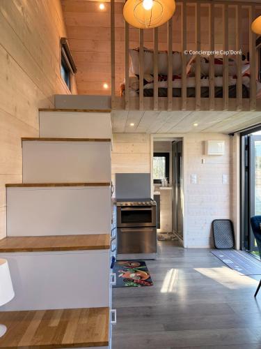 a kitchen with stairs leading up to a loft at Le Cabanon - Tiny House 150m de la Plage in Portbail