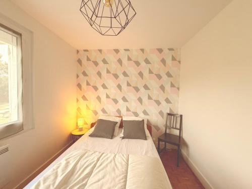 a bedroom with a bed with a geometric wall at A CasA in Linxe