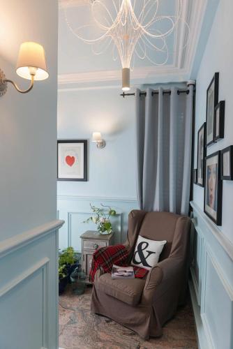 a living room with a chair and a chandelier at Areela Boutique Hotel in Tirana