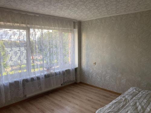 an empty room with a window and a bed in a room at Apiņa 18 in Valmiera