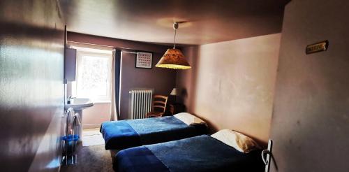 a bedroom with two beds and a light fixture at Atelier du pont de Mars in Mars