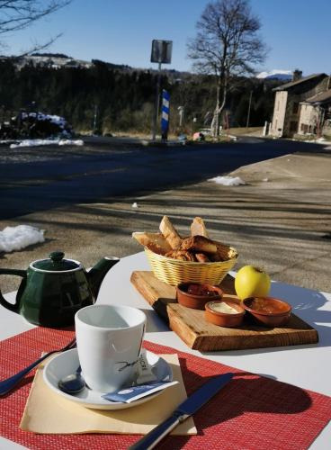 a table with a cup of coffee and a basket of bread at Atelier du pont de Mars in Mars