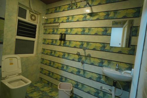 a bathroom with a toilet and a sink at Kasa Courtyard Hotel in Begusarai