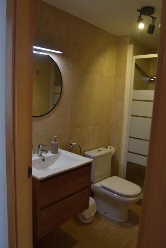 a bathroom with a toilet and a sink and a mirror at Apartament Lo Passador in Deltebre