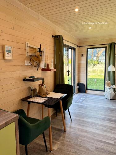 a dining room with a table and chairs and a window at La Roulotte - Tiny House 150m de la Plage in Portbail