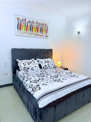 a bed with a black and white comforter in a bedroom at Lumora Homes in Arusha