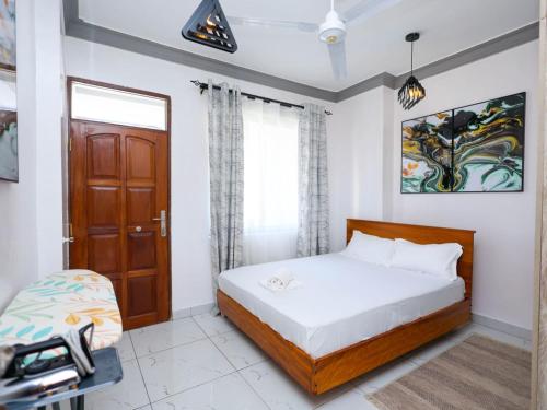 a bedroom with a bed and a window and a door at Cosy 1 Bedroom in CBD Mombasa with City View in Mombasa