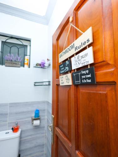 a door in a bathroom with signs on it at Cosy 1 Bedroom in CBD Mombasa with City View in Mombasa