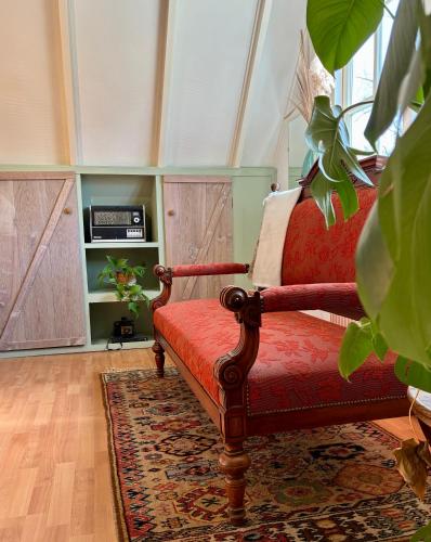 a living room with a red chair and a rug at LooSan Lodges Gastenhuis in Reutum