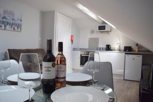 a table with two bottles of wine and two glasses at Malton Central Apartments in Malton