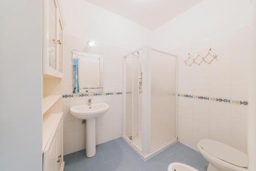 a white bathroom with a sink and a shower at Casa del passero - Villa with Infinity Garden and Sea View in Forio d'Ischia