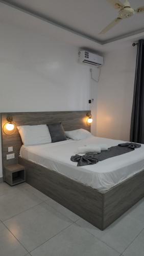 a large bed in a room with two lights at vale mombasa nyali in Mombasa