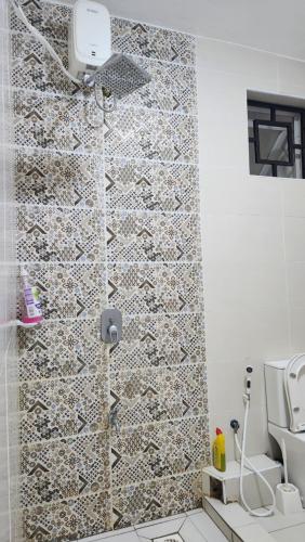 a bathroom with a shower with a tile wall at vale mombasa nyali in Mombasa