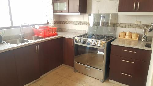 a kitchen with a stove and a sink at Casa Vacacional in Cuenca