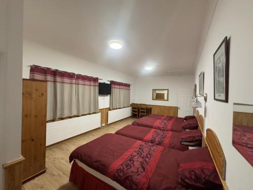 a bedroom with two beds with red comforter at The Dharma Lodge in Enfield