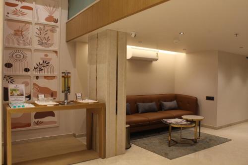 a living room with a couch and a table at Hotel Midtown in Surat