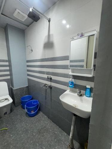 a bathroom with a sink and a toilet and a mirror at Harmony House in Ghaziabad
