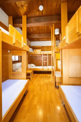 a room with three bunk beds and wooden floors at Hostel Feldkirch in Feldkirch