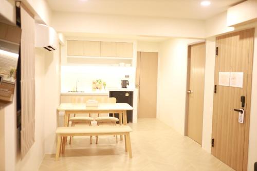 a small kitchen with a table and chairs in a room at Kim Poshtel Hatyai in Hat Yai