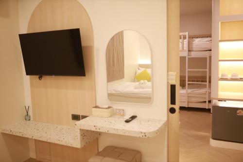 a living room with a tv and a mirror at Kim Poshtel Hatyai in Hat Yai