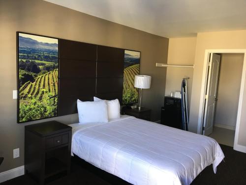a hotel room with a large bed with a view at Vallejo Inn in Vallejo