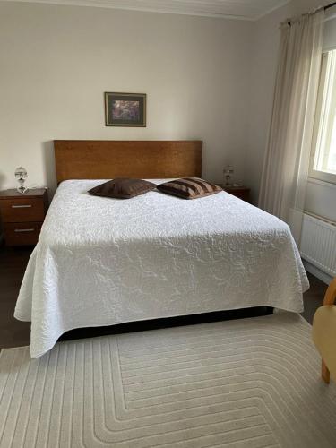 a bedroom with a bed with a white comforter at Kaliininkuja 1 in Lapua