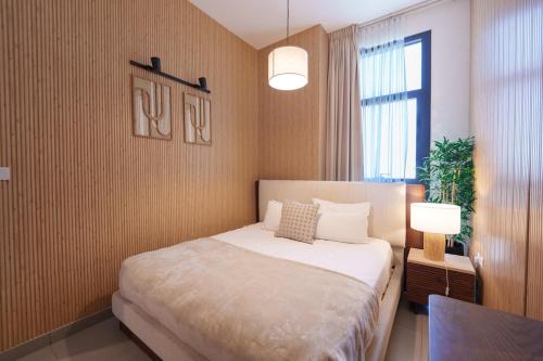 a bedroom with a bed and a table and a window at Golden Sunset Luxe 1BR CB2-3-RA1-812-1br in Sabkhah