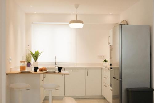 a kitchen with white cabinets and a refrigerator at Nila 1 by Huskalia in Los Llanos de Aridane