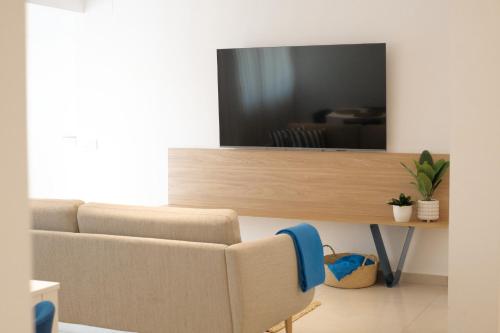 a living room with a couch and a television at Nila 1 by Huskalia in Los Llanos de Aridane