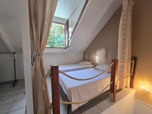 a bedroom with two bunk beds and a window at Maison Désirée in Sainte-Anne