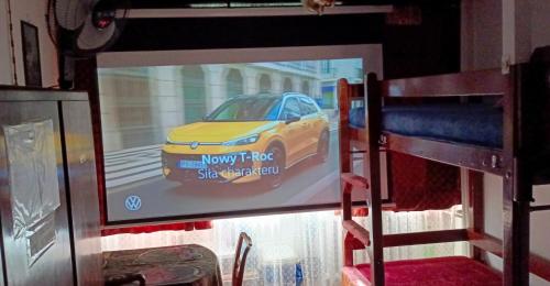 a screen with a picture of a yellow car on it at Room for you in Warsaw